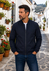 Chaqueta bomber clásica para hombre azul oscuro, en un pueblo del sur de España.