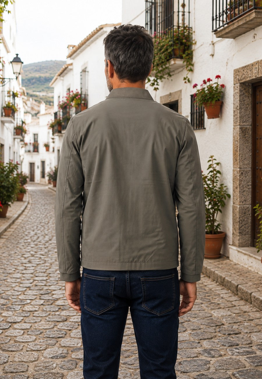 Chaqueta bomber clásica para hombre color kaki, de espaldas en pueblo del sur de España